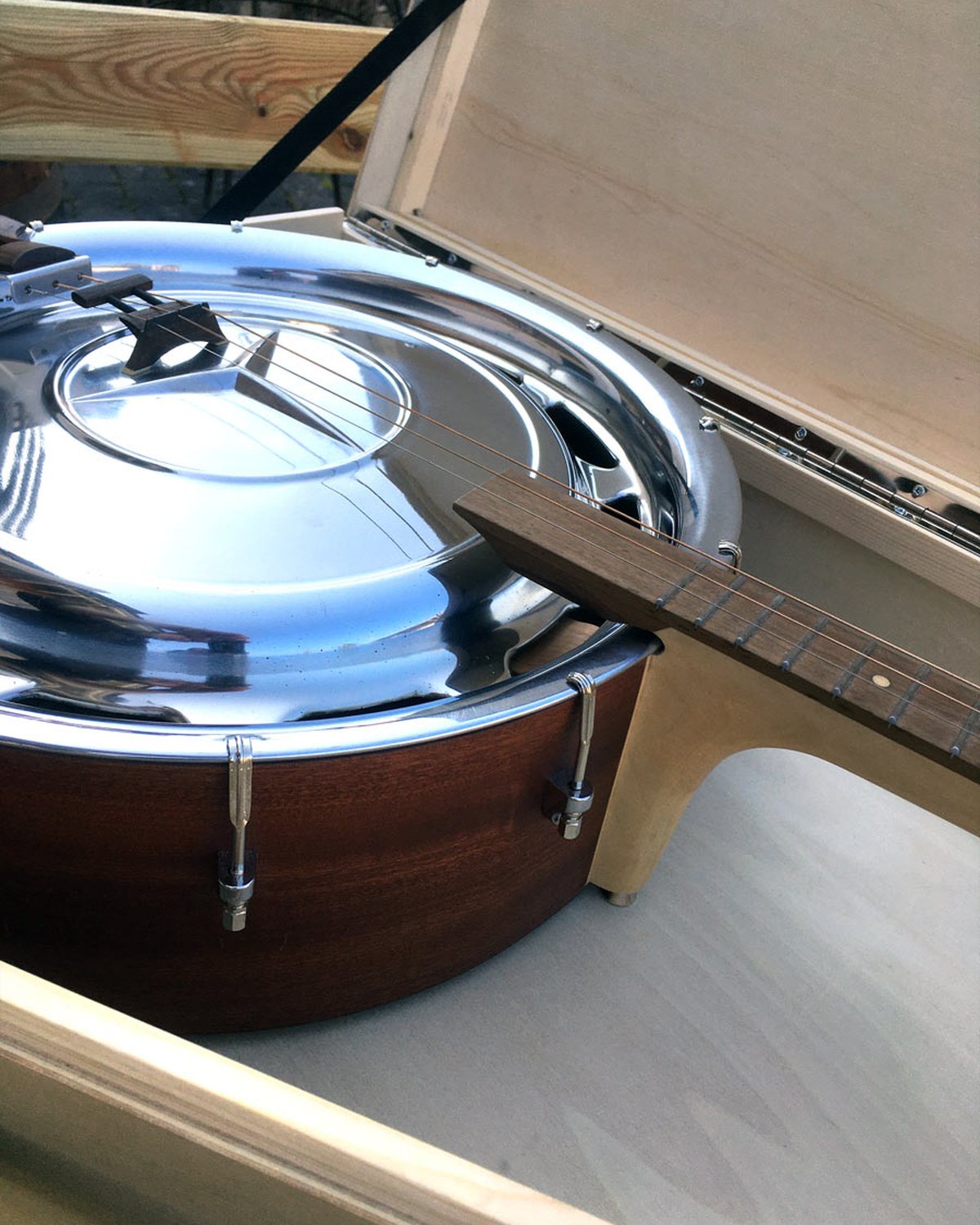 3Saiter Hubcap Guitar im geöffneten Instrumentenkoffer