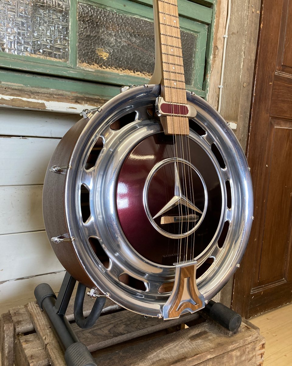 Detail von Halsansatz, Holz und Metall einer 3Saiter Hubcap Guitar